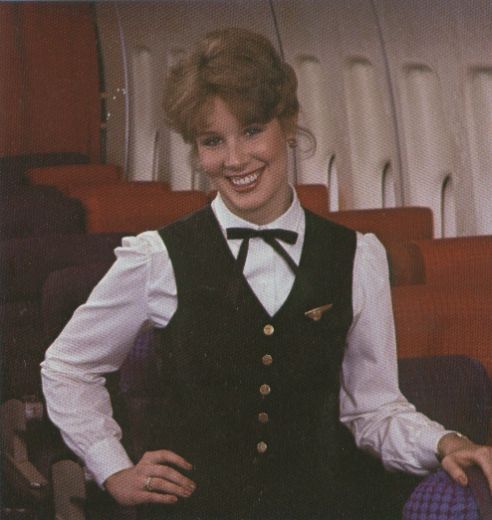 1980s A Pan Am Flight Attendant poses in the economy section of a 747.